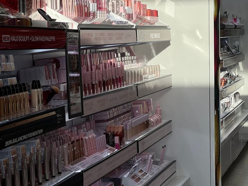 Premium cosmetics display with makeup, skincare, and beauty products on retail shelves